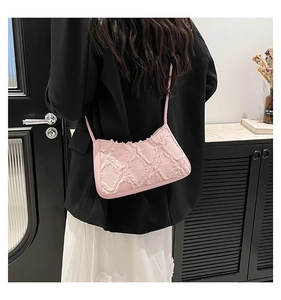 Pink frayed denim underarm bag with diamond quilted pattern worn with a black blazer