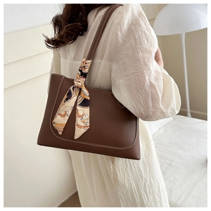 Détail du grand sac cabas marron en cuir avec surpiqûres blanches et foulard en soie décoratif