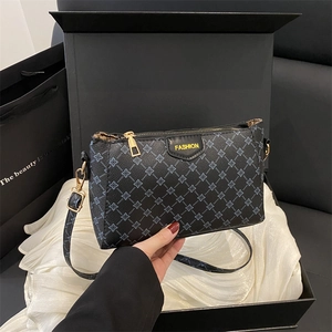 Borsa a tracolla da donna in PU nero con stampa floreale blu su una confezione regalo
