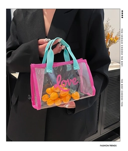 Close-up of transparent PVC tote bag with pink love print and teal woven handles
