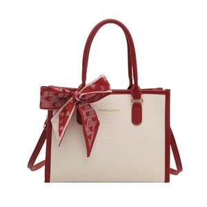 Elegant ivory tote bag with red leather trim and silk scarf accent in snake texture