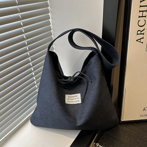 Ethnic patchwork dark blue denim shoulder bag with drawstring closure and brand label