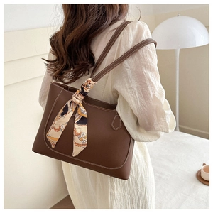 Détail d'un grand cabas en cuir marron avec surpiqûres blanches et foulard en soie décoratif
