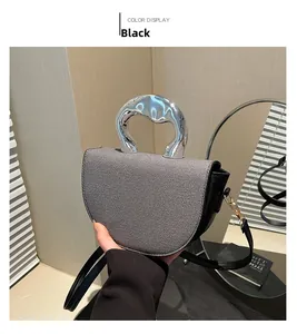 Détail du sac selle avec rabat en tweed, poignée métallique et bandoulière noire