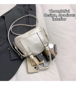 Dettaglio dello spazio interno della borsa in ecopelle color crema con oggetti personali