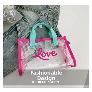 Detail view of transparent PVC tote bag with pink trim, mint green handles, and Love text