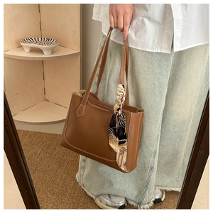 Détail du sac cabas marron foncé avec surpiqûres blanches et foulard en soie décoratif