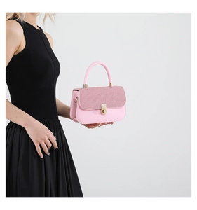 Détail du petit sac carré rose avec rabat texturé et fermoir en métal doré élégant