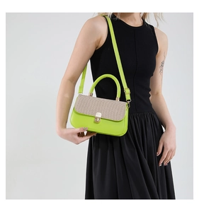 Detail of a bright green crossbody bag with beige woven flap and golden twist lock clasp