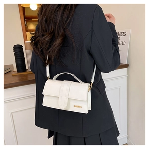 Vue détaillée du sac à main blanc minimaliste en cuir avec logo doré et bandoulière