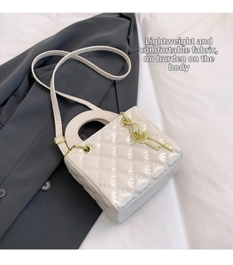Detail of cream quilted crossbody bag featuring diamond patterns and golden hardware