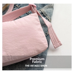 Dettaglio della borsa a tracolla rosa con cuciture fini e nylon resistente all'acqua