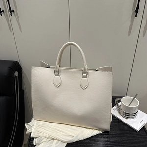 Sac cabas élégant blanc cassé avec motif crocodile et poignées rondes sur fond noir