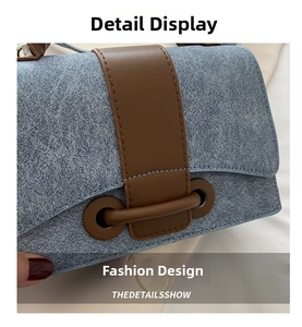 Detailed close-up of blue denim texture and brown leather trim on the shoulder bag