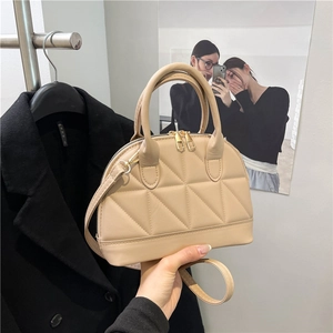 Quilted apricot shoulder bag with shell silhouette and metallic zipper details