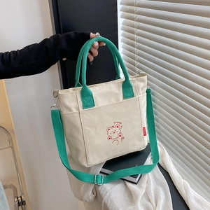 Canvas tote bag with green handles and cute cartoon bear print in casual chic style