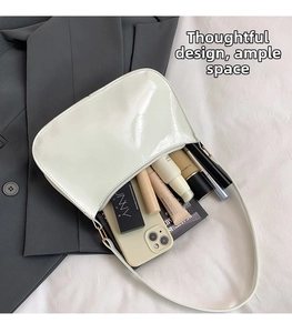 Interior view of white patent leather shoulder bag showing its large storage capacity