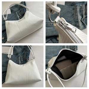 Macro detail of white pleated tote bag showing fabric texture, silver zipper, and capacity