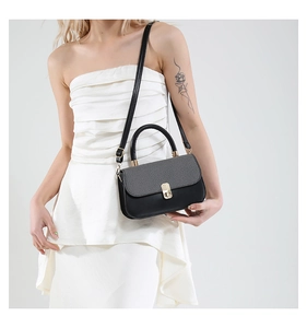Détail du sac carré bicolore avec fermoir doré et rabat en tissu à chevrons gris