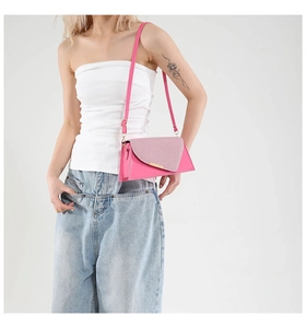 Detail van rozerode crossbodytas met een roze glitterflap en goudkleurige hardware