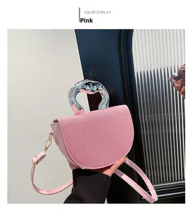 Détail du sac selle rose avec texture en tissu et poignée en métal argenté