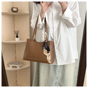 Sac fourre-tout marron en similicuir avec coutures blanches et foulard sur modèle