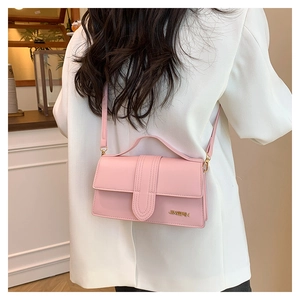 Pink minimalist crossbody bag styled with a white blazer in a modern cafe setting