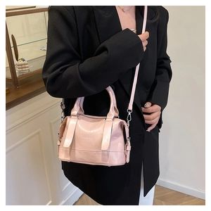 Dettaglio della borsa in pelle rosa con lettere a rilievo e tracolla regolabile