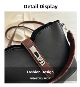 Close-up of silver metal twist lock and stitching detail on a black leather handbag