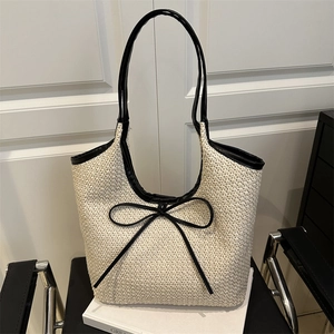 Sac fourre-tout en paille tissée avec poignées en cuir noir et nœud décoratif