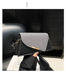 Detail van een hippe vierkante crossbodytas van zwart leer met een grijze stoffen flap
