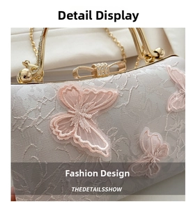 Close-up of pink butterfly embroidery on a lace handbag with a golden bow clasp