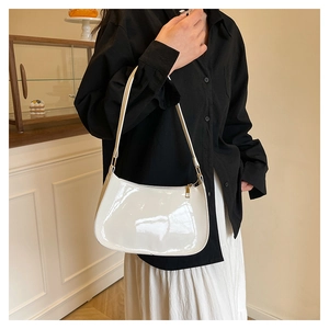 Close-up of a creamy white glossy underarm bag with a minimalist retro design