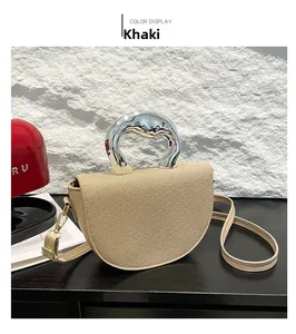 Détail du sac selle kaki avec texture tissée et poignée unique en métal argenté