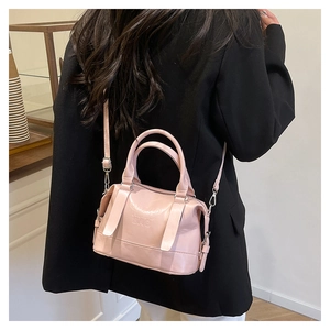 Dettaglio borsa in pelle PU rosa lucida con scritte in rilievo e finiture in metallo argentato