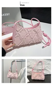 Dettaglio della borsa a mezzaluna in denim rosa con trapuntatura sfrangiata e nodi