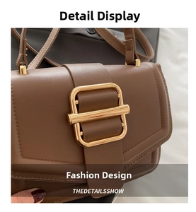 Detailed view of brown leather bag featuring square gold buckle and precise stitching