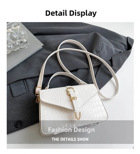 Détail de la texture crocodile blanche avec boucle en métal doré sur le sac