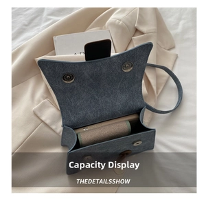 Internal capacity of blue denim crossbody bag showing space for phone and cards