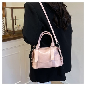 Borsa a tracolla rosa con scritta NING BAG indossata su un completo nero elegante