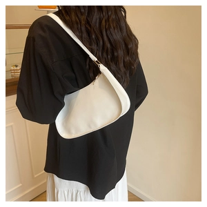 Rear view of model wearing a sleek white leather hobo shoulder bag in a modern style