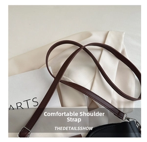 Close-up of brown leather shoulder strap with stitching and metal buckle detail