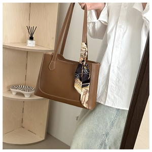 Sac cabas en cuir marron avec surpiqûres contrastées et foulard en soie sur la poignée