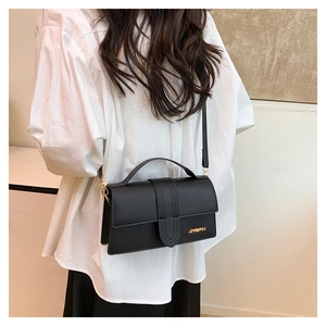 Close-up of black matte leather crossbody bag with golden JINGPIN logo and vertical stitching
