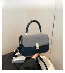 Détail du sac à main avec fermoir doré tournant et poignée cylindrique chic