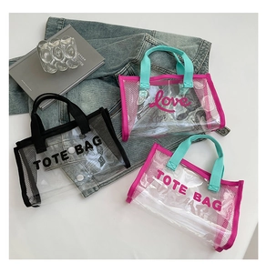 Close-up of transparent PVC tote bag featuring contrast stitching and grid side panels