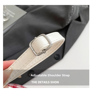 Detail of adjustable white leather strap with silver metal buckle and stitching