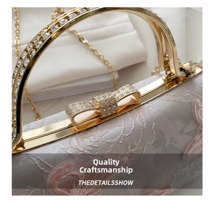 Close-up of sparkling rhinestone bow clasp and golden metal handle on lace bag