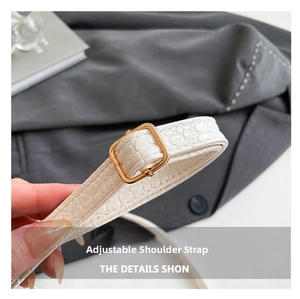 Détail de la bandoulière réglable sur petit sac carré blanc en simili cuir crocodile