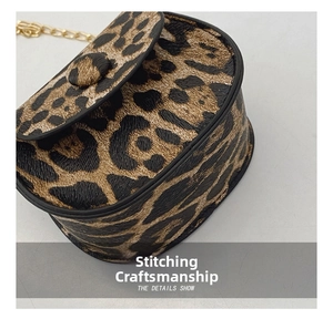 Close-up of leopard print saddle bag showing fine stitching and gold chain strap details
